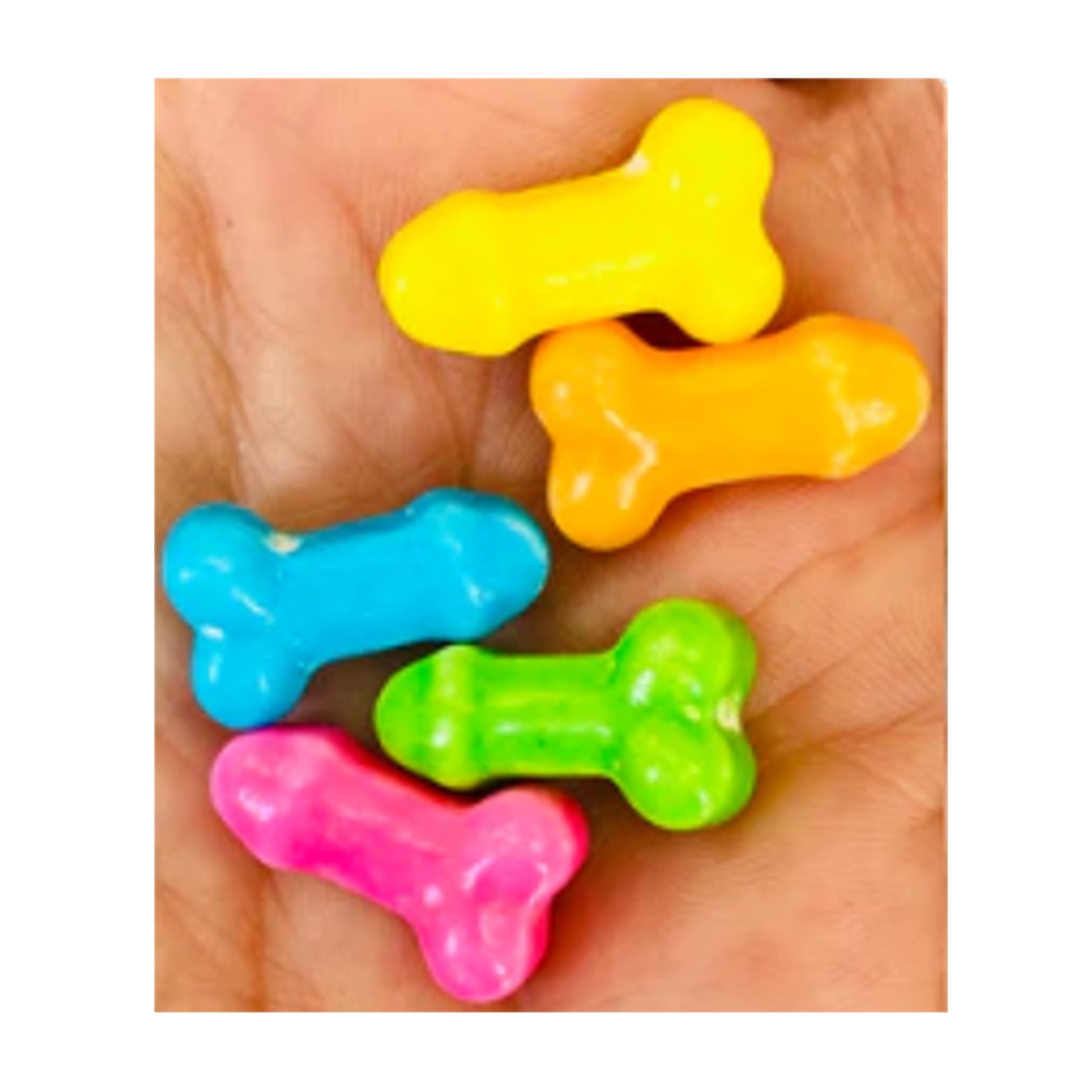 Dick-shaped candies close up in hand out of packaging