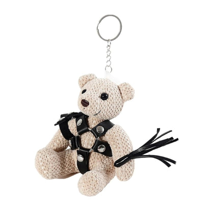 Angled front view of teddy keychain wearing black harness