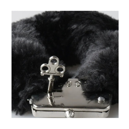 Close-up of handcuff key beside leopard plush cuff