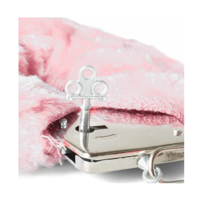 Close-up of handcuff key beside pink plush cuff